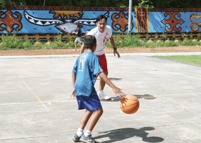 艾力克斯上場和偏鄉孩子玩籃球。（伊甸基金會提供）