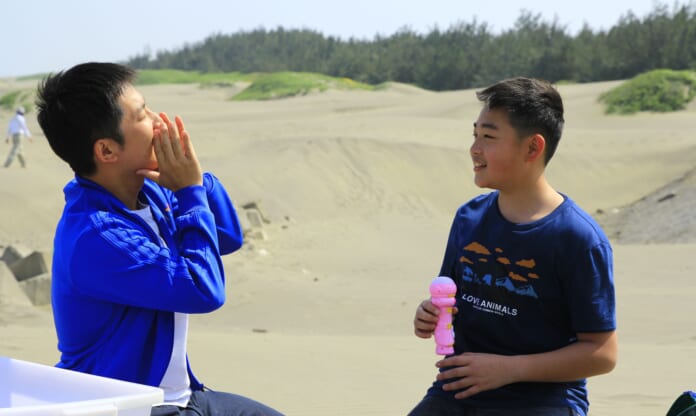 蔡昌憲（左）與黃承毓前往台南七股區篤加村體驗學習「數魚歌」。（公視提供）